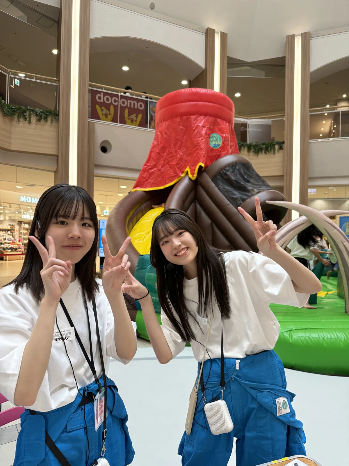 恐竜火山ふわふわの前に立つ運営スタッフ2名