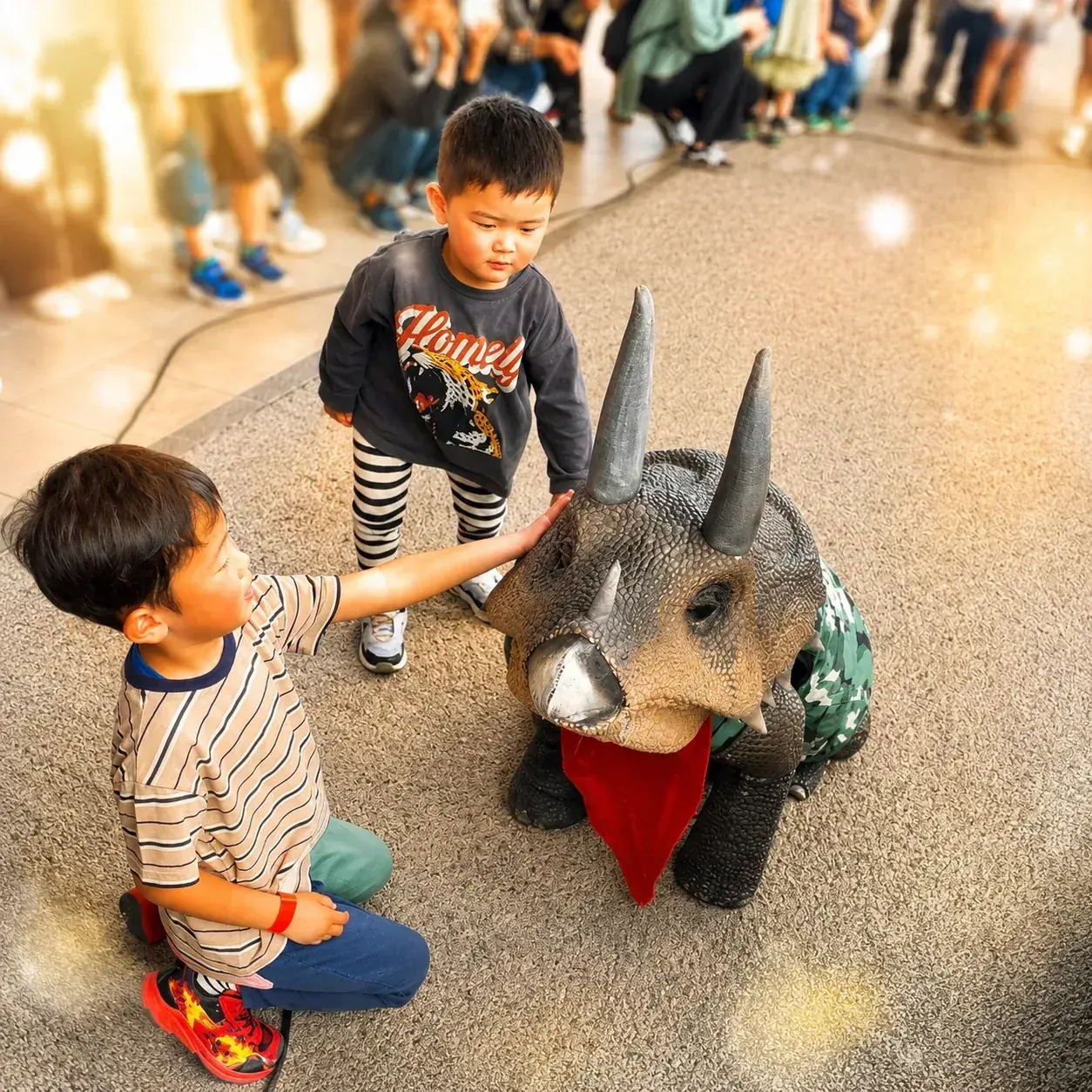 2人の子供がトリぼんに近づいてふれあっている様子